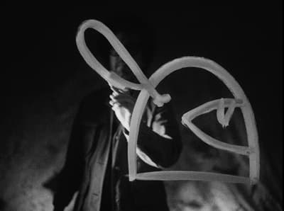 a black and white photo of a man holding a heart