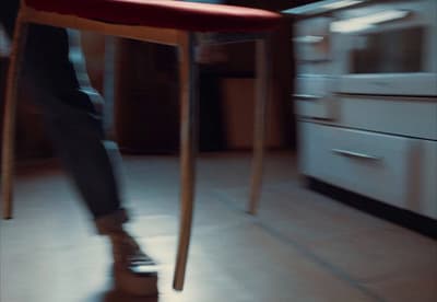 a person standing on a stool in a kitchen