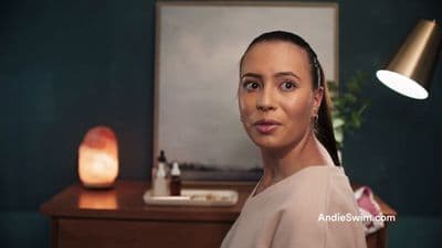 a woman standing in front of a table with a lamp on it