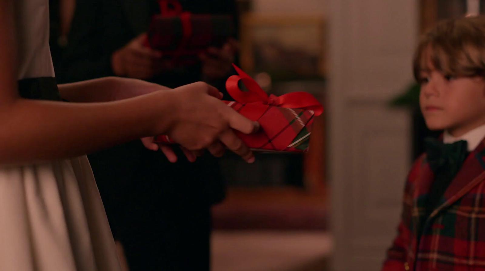 a little boy holding a red present box