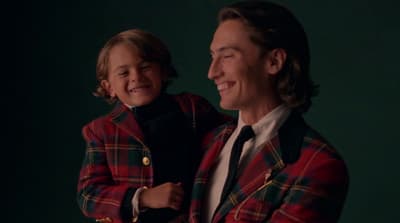 a man in a red and black jacket holding a child