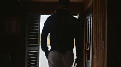 a man standing in front of a door with his back to the camera
