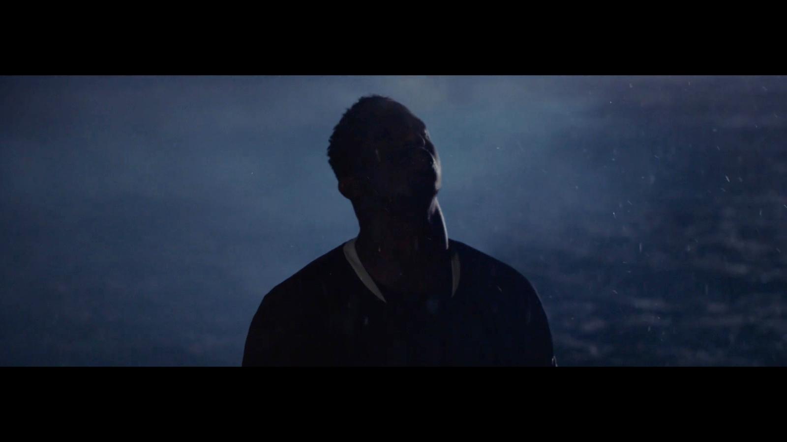 a man standing in the rain at night
