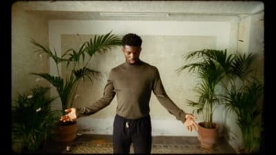 a man standing in a room with potted plants
