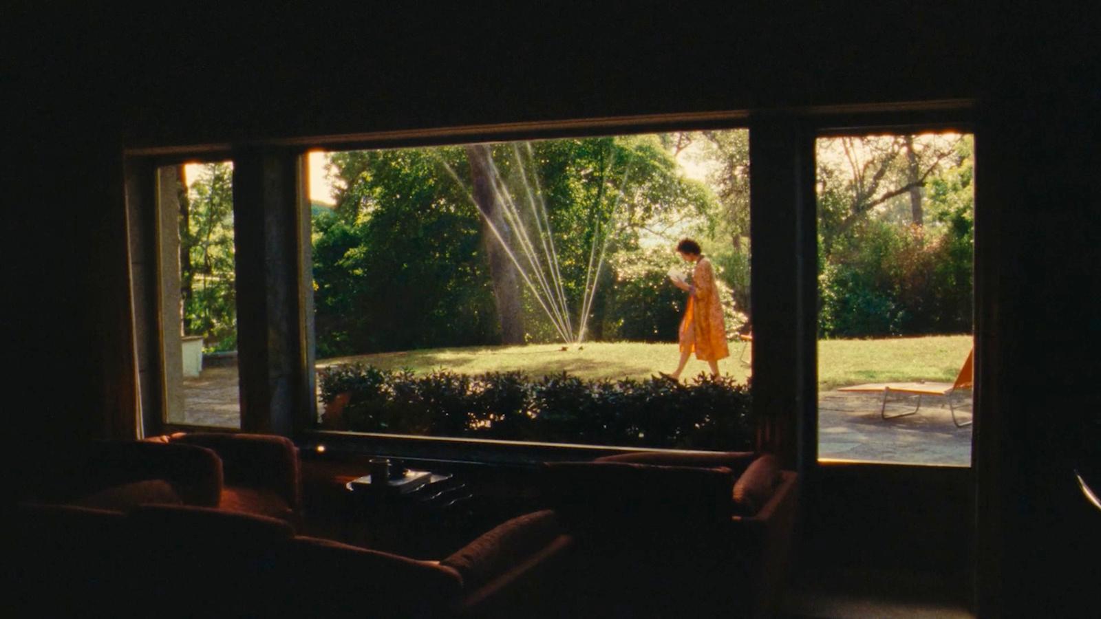 a woman standing in a living room next to a window