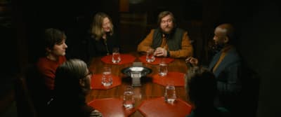 a group of people sitting around a wooden table