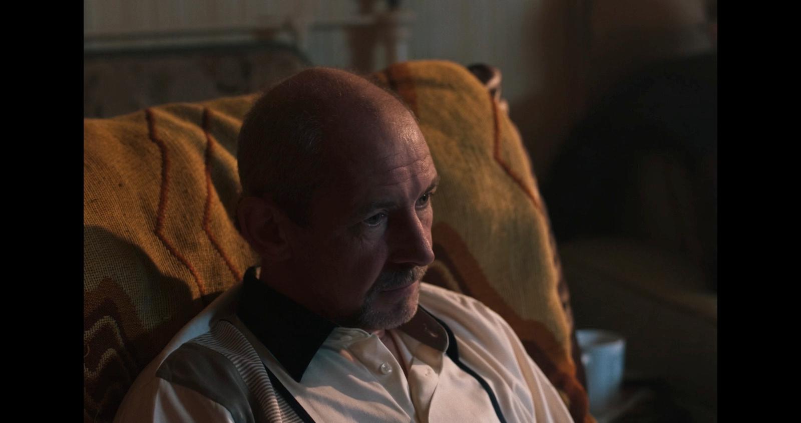 a bald man in a white shirt and tie