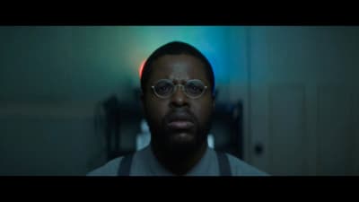 a man wearing glasses in a dark room