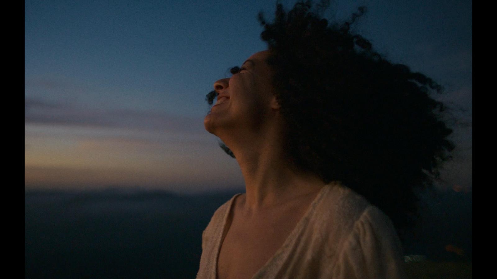a woman with her eyes closed looking up at the sky