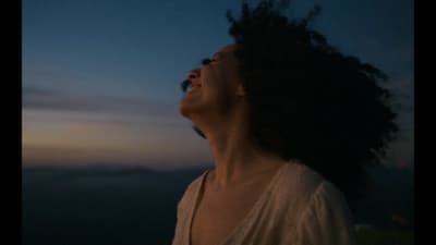 a woman with her eyes closed looking up at the sky