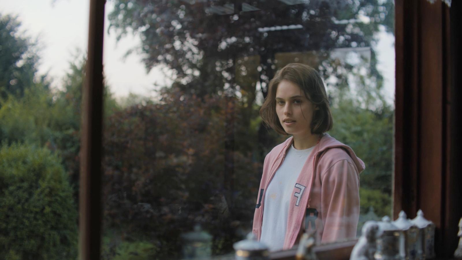 a woman standing in front of a window