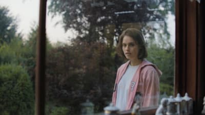 a woman standing in front of a window