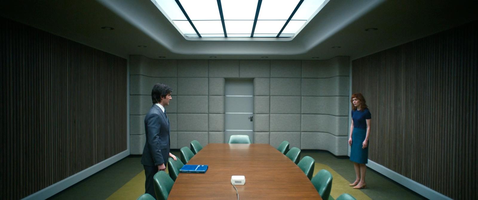 a man and a woman standing in a conference room
