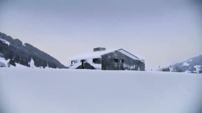 a house in the middle of a snowy field