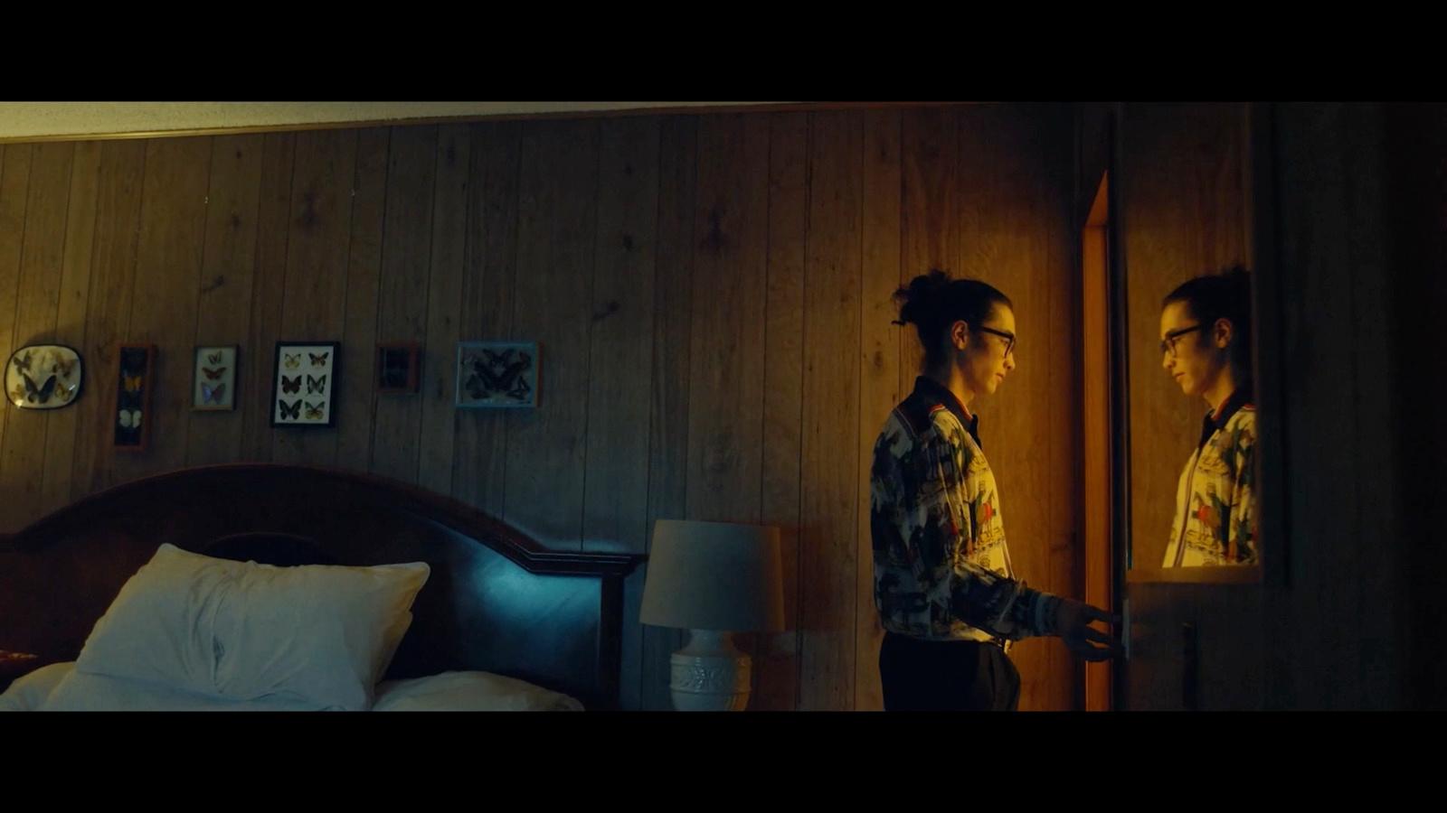 a man standing in front of a mirror in a bedroom