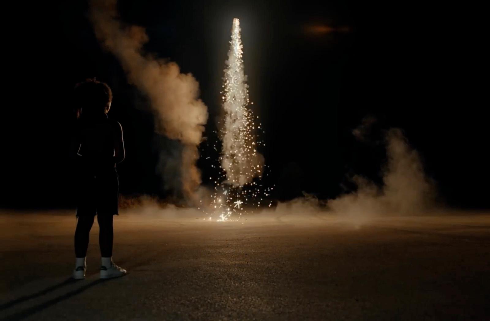 a person standing in the middle of a street watching fireworks