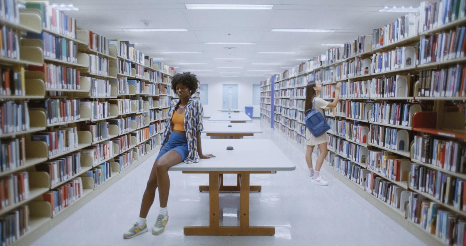 two women sitting at a table in a library