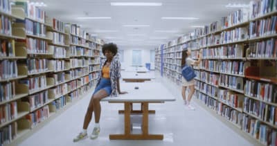 two women sitting at a table in a library