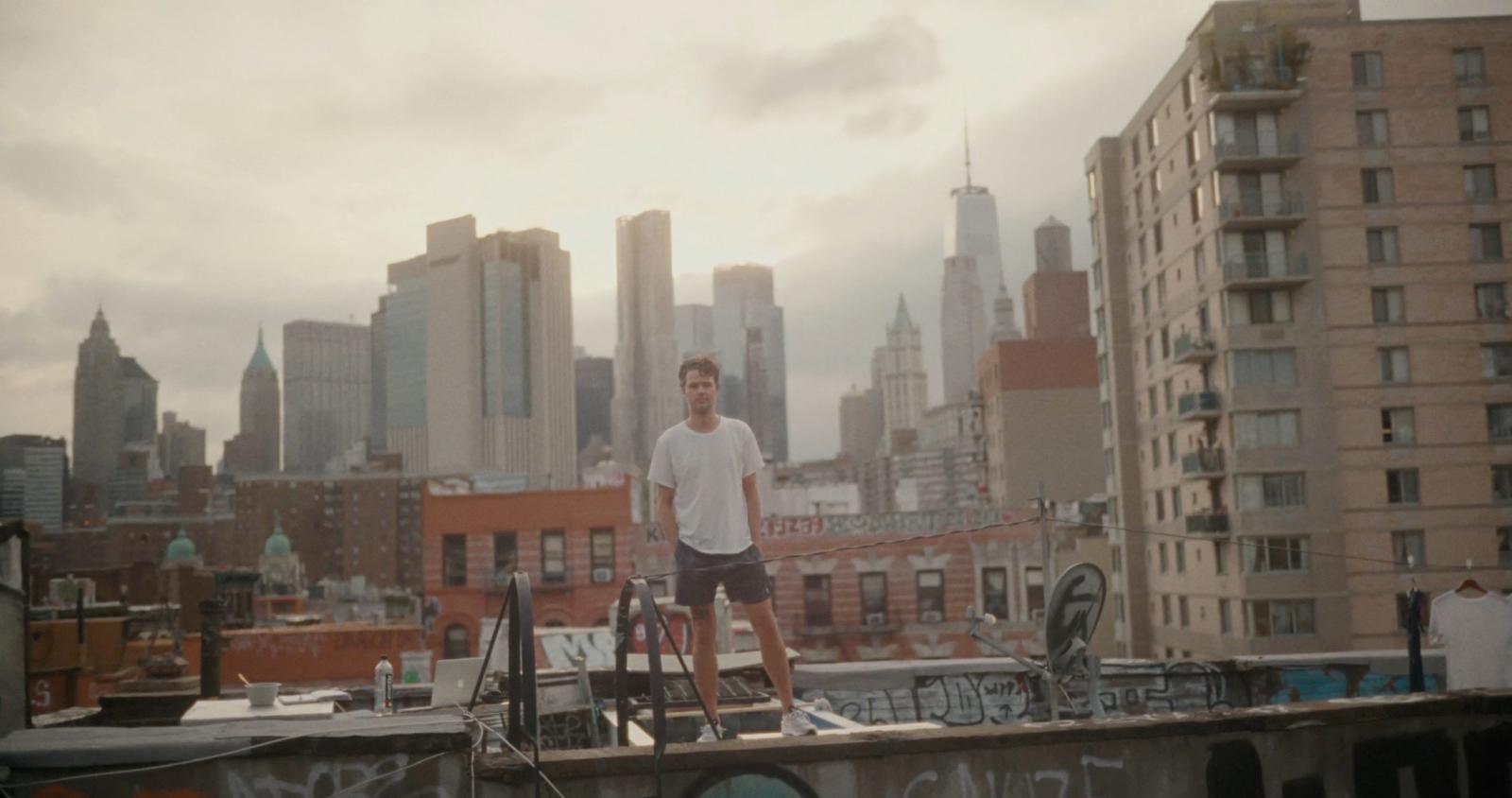 a man standing on top of a roof next to a bike