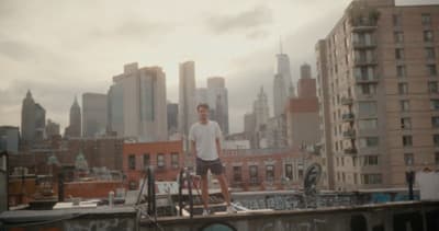 a man standing on top of a roof next to a bike