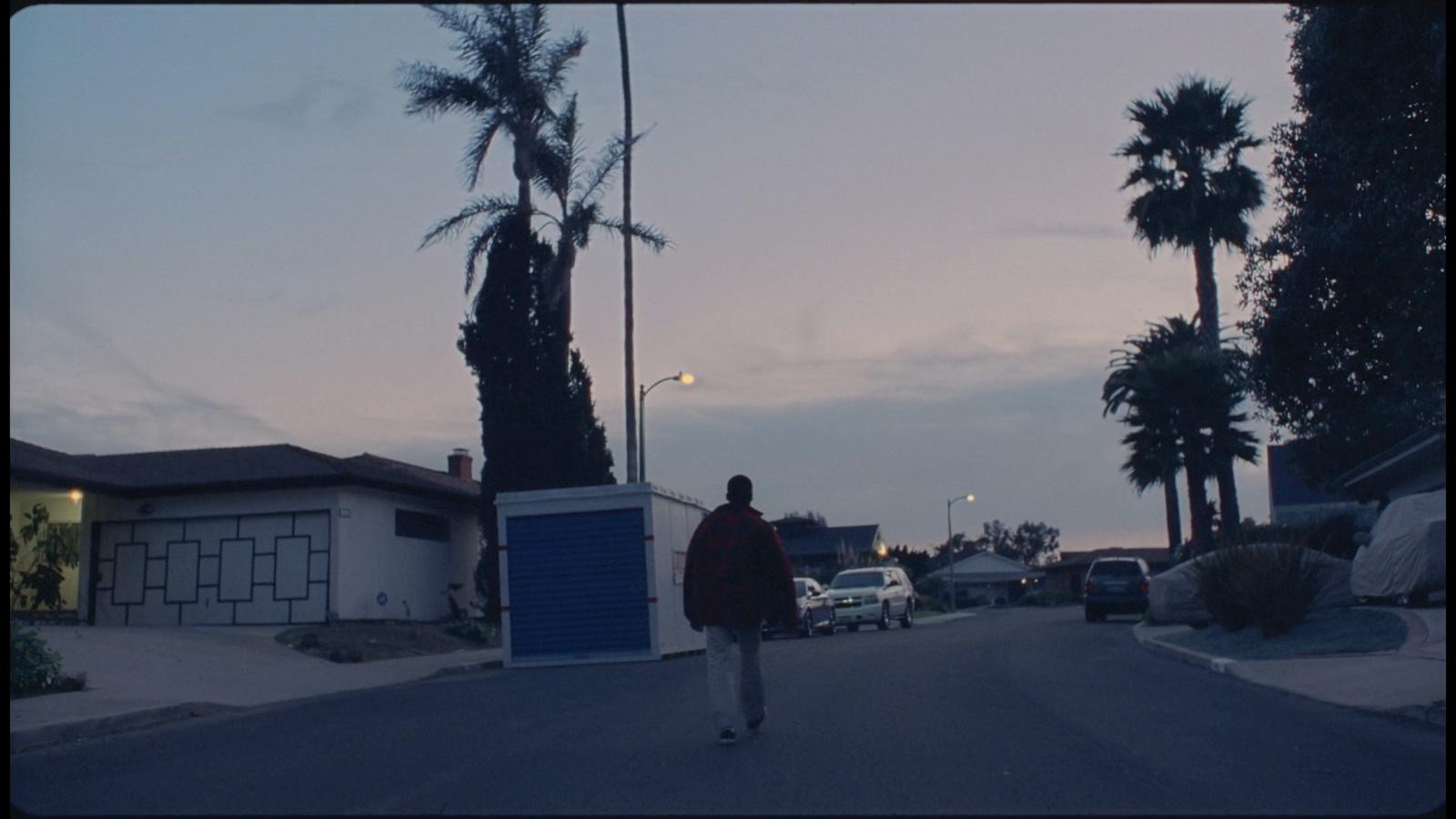 a person walking down a street at dusk