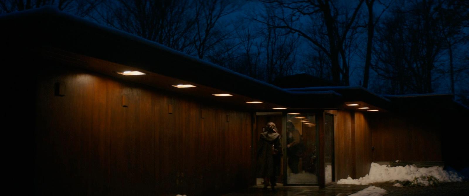 a man standing outside of a building at night