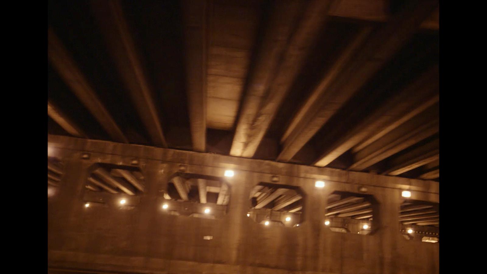 a view of the underside of a bridge at night