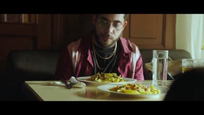 a man sitting at a table in front of a plate of food