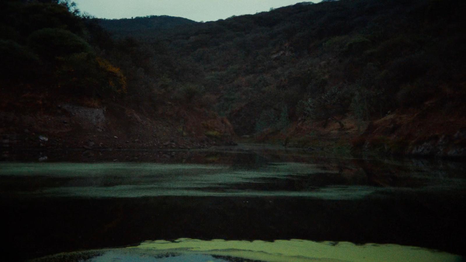 a body of water with a mountain in the background