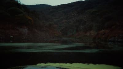 a body of water with a mountain in the background