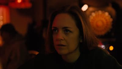 a woman in a dark room staring at something