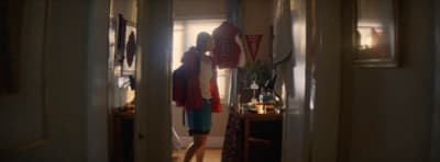 a person standing in a doorway with a red object