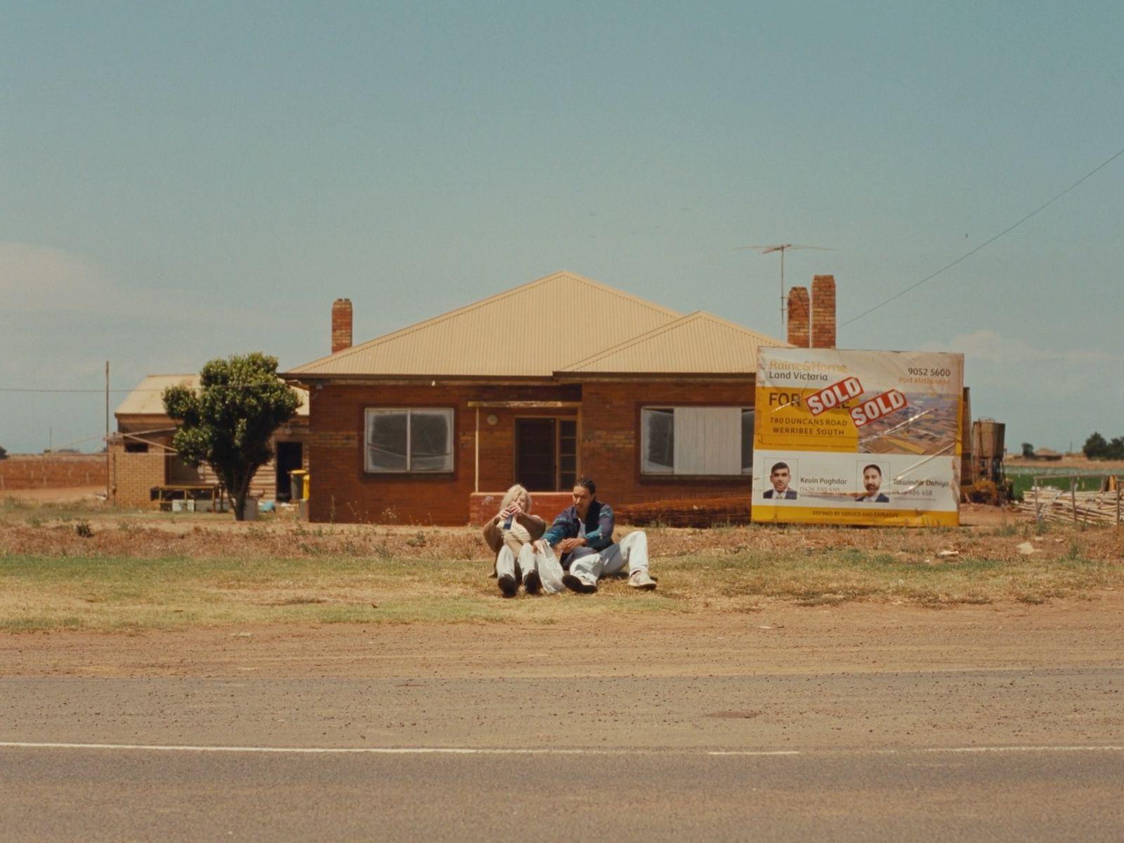 a couple of people sitting on the side of a road