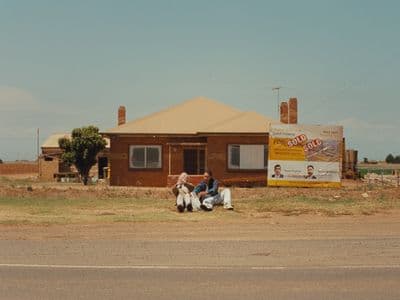 a couple of people sitting on the side of a road