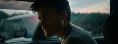 a man sitting in a car looking out the window