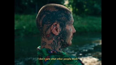 a man with tattoos on his face and neck