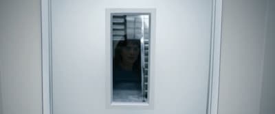 a woman standing in front of a white door