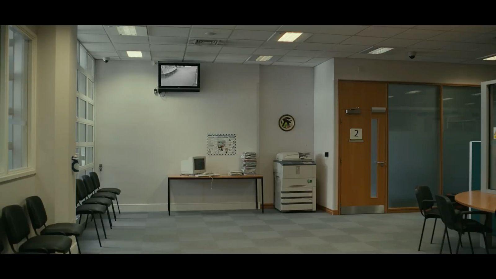 a room with chairs, a table and a television