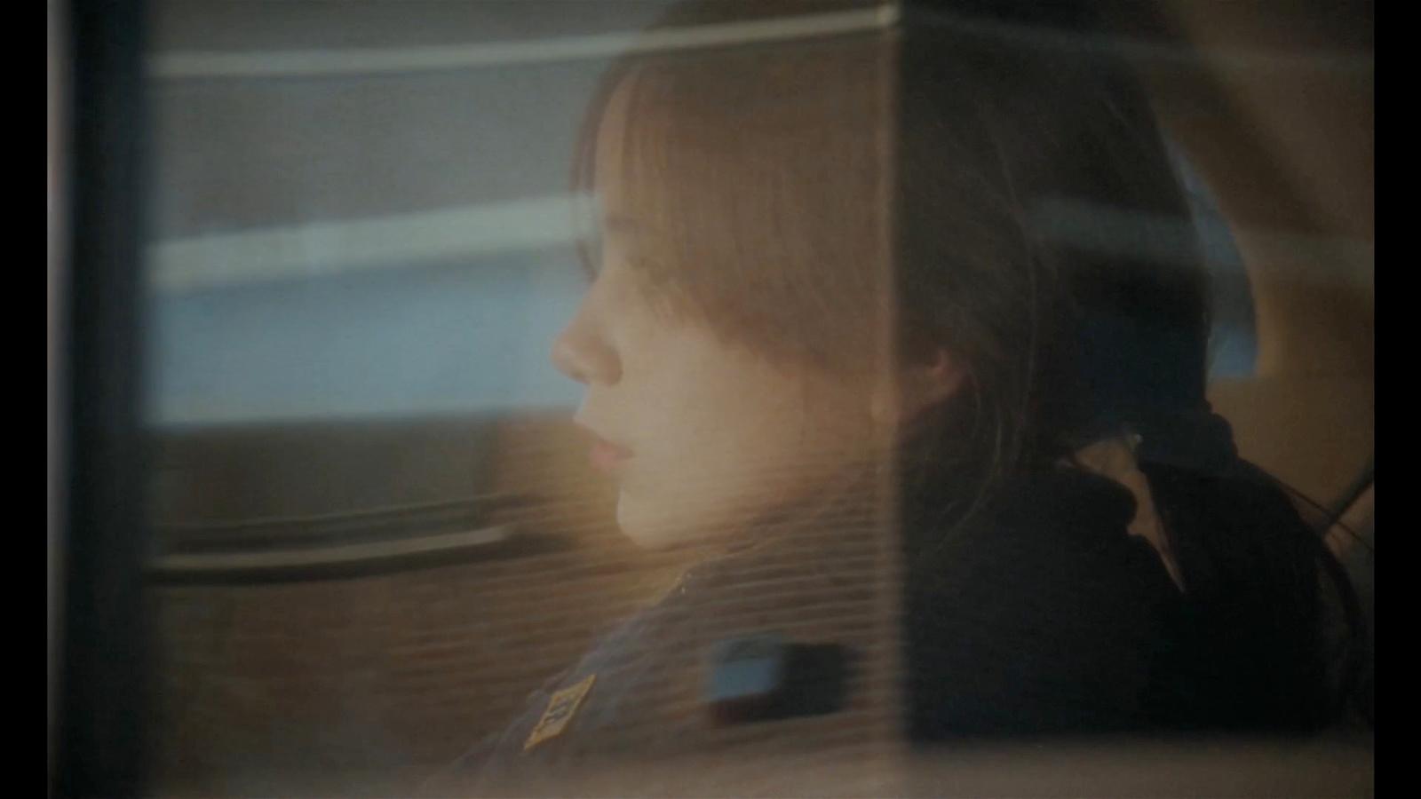 a little girl sitting in a car looking out the window