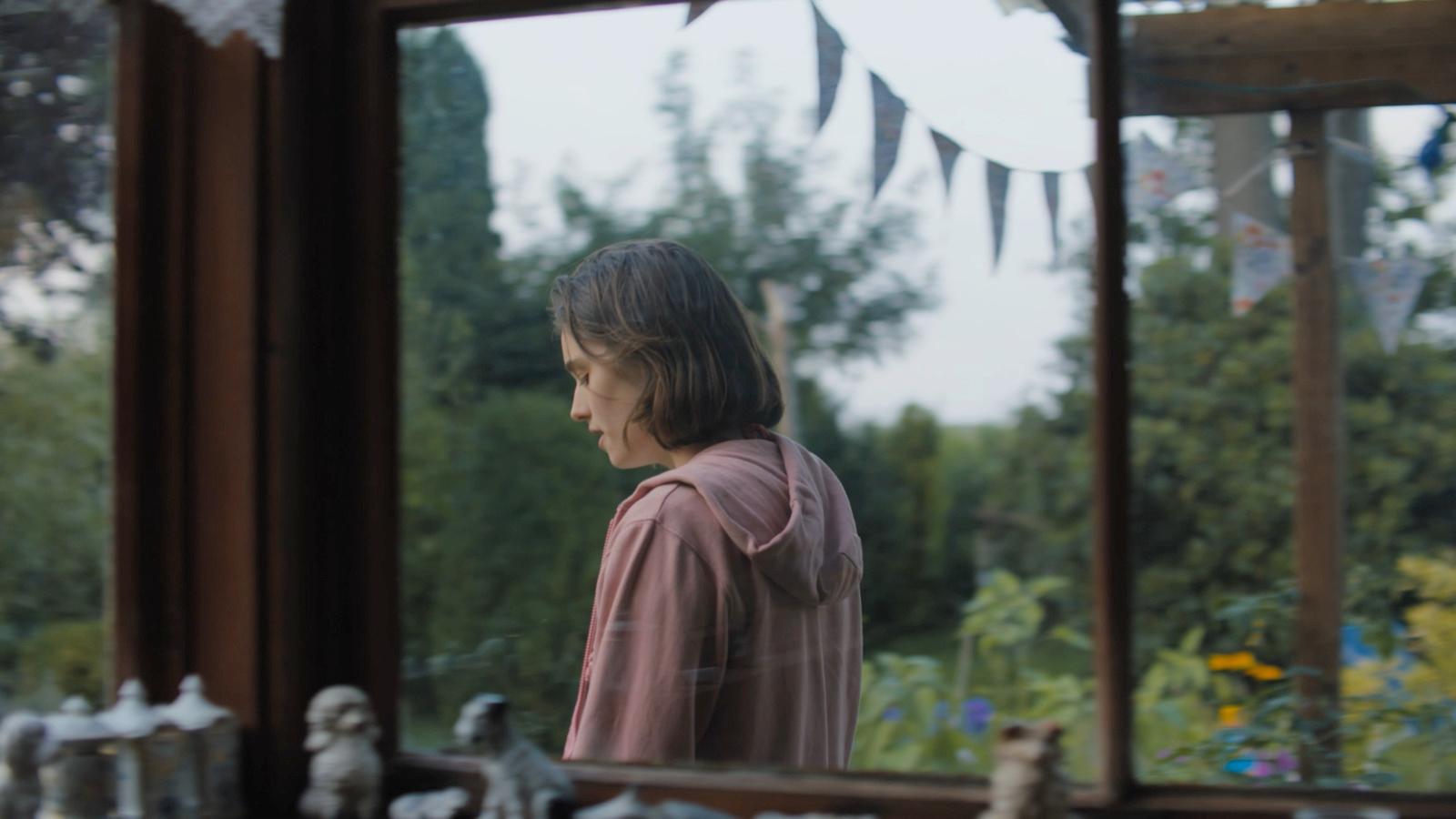 a young girl looking out of a window