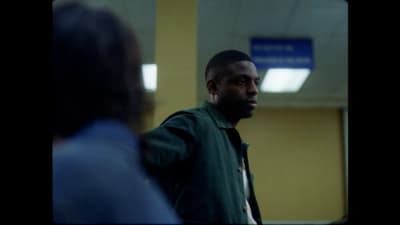 a man in a green jacket standing next to another man