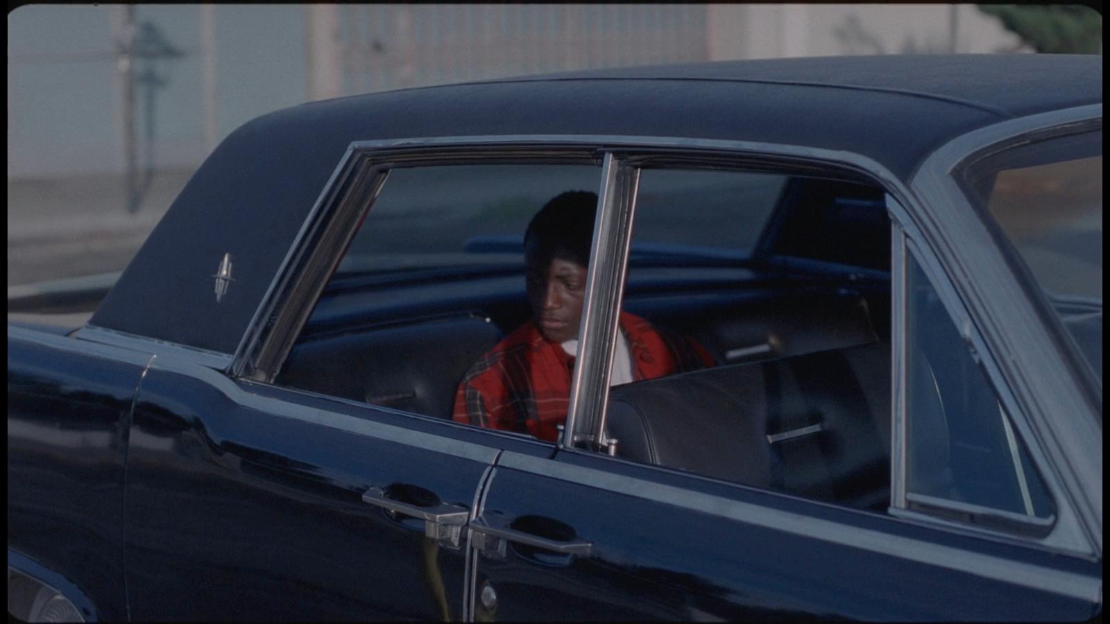a man sitting in a car looking out the window