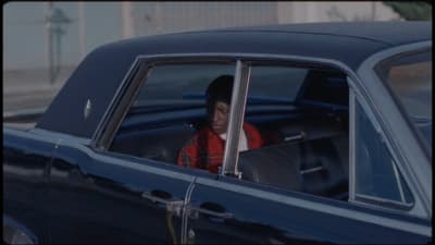 a man sitting in a car looking out the window