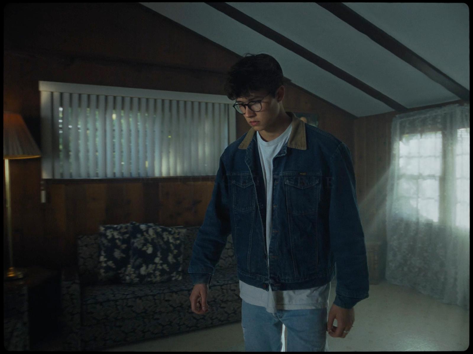 a man standing in a living room next to a couch