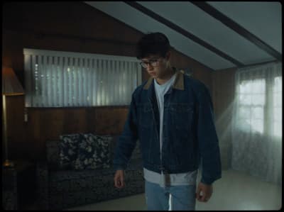 a man standing in a living room next to a couch