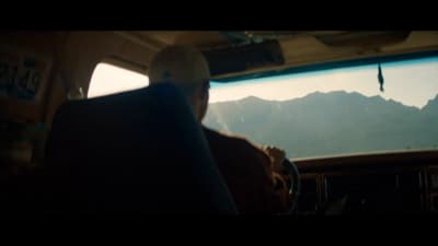 a man sitting in the back of a bus looking out the window
