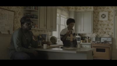 a man and a woman sitting at a kitchen counter