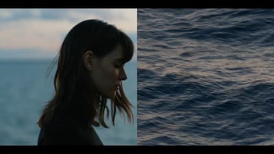 a woman standing in front of a body of water