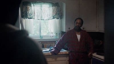 a man standing in a kitchen next to a window
