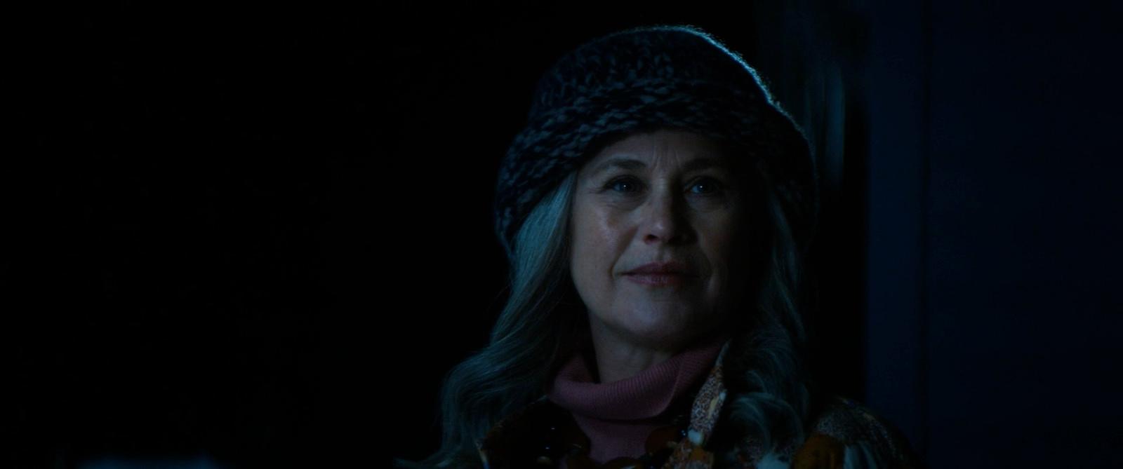 a woman wearing a hat in the dark